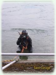 Le plongeur ressort du rhin après avoir procédé au curage à Rhinau